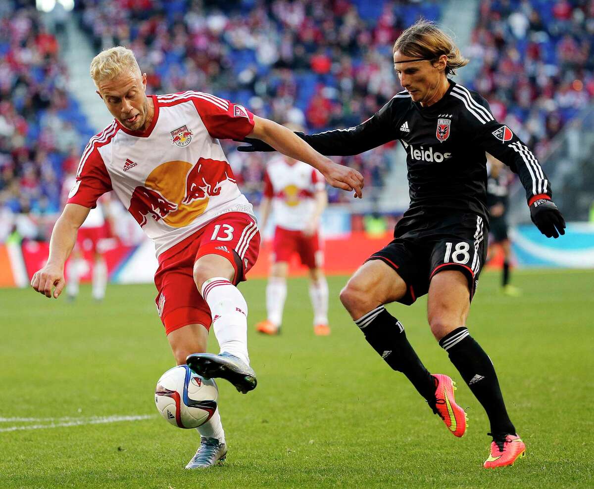 New York Red Bulls forward Mike Grella, left, dribbles against D.C. United forward Chris Rolfe during the first half Sunday.