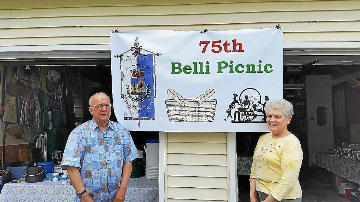 Jerry Belli and wife Gaye Belli, both 70, stand in front of a banner for the Belli family reunion, which was held at their home on Mountain Road in Torrington on Saturday.