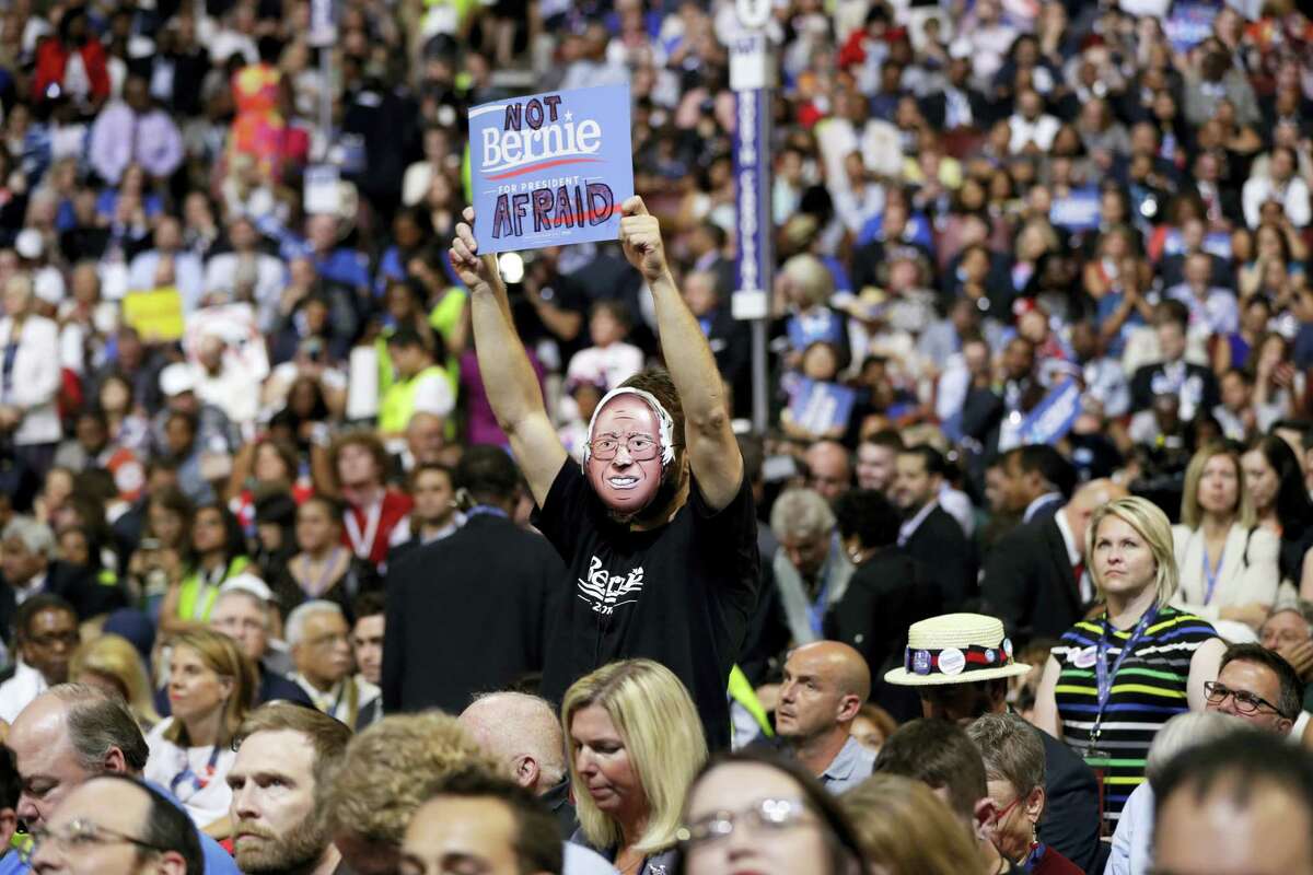 Supporter for former Democratic presidential candidate, Sen. Bernie Sanders, I-Vt., holds up a sign as President Barack Obama speaks during the third day session of the Democratic National Convention in Philadelphia, Wednesday, July 27, 2016.