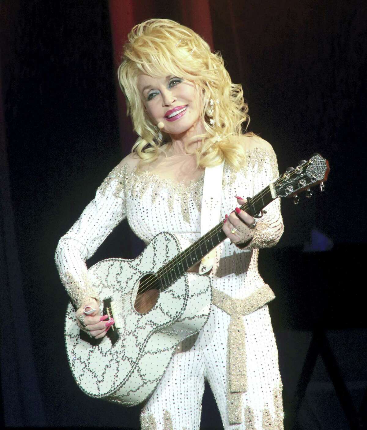 In this June 15, 2016, file photo, Dolly Parton performs in concert during her Pure & Simple Tour in Philadelphia. Parton will receive the Willie Nelson Lifetime Achievement Award at the 50th annual Country Music Association Awards in Nashville, Tenn., on Nov. 2.