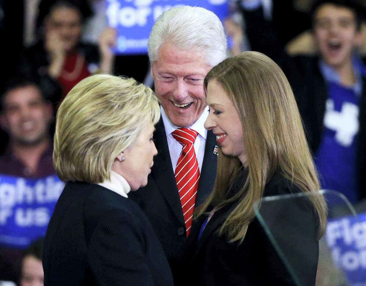 In this Feb. 9, 2016 photo, Democratic presidential candidate Hillary Clinton huddles with her husband, former President Bill Clinton and daughter Chelsea at her New Hampshire presidential primary campaign rally in Hooksett, N.H.