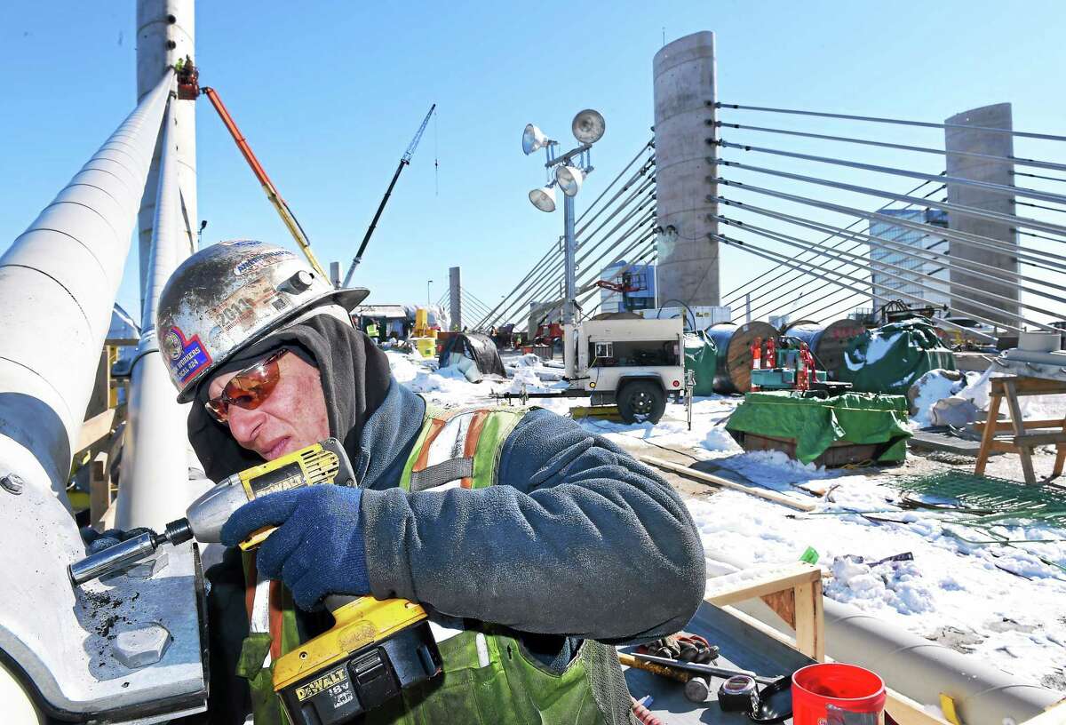 ARNOLD GOLD — NEW HAVEN REGISTER Michael Shaw installs bolts on a collar for the stay cable dampeners on the Pearl Harbor Memorial Bridge in New Haven on Friday.