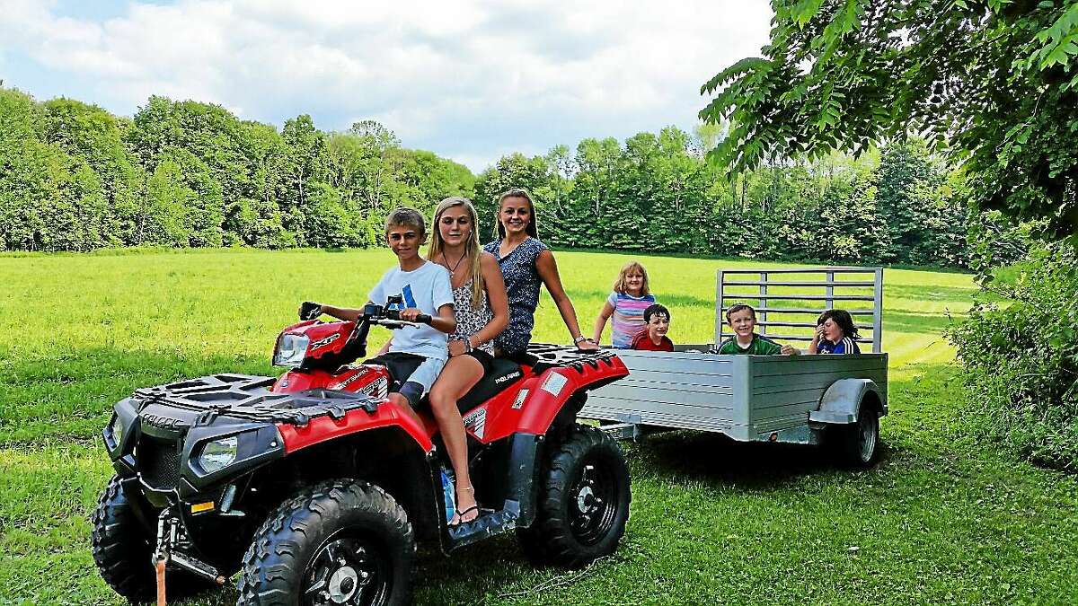 Matthew Mazzarelli, 13, drove a tractor with sisters Kaitlyn Mazzarelli, 15, and Emily Mazzarelli, 18, all of Torrington, to take children on a hayride at the Belli family reunion on Mountain Road in Torrington Saturday.