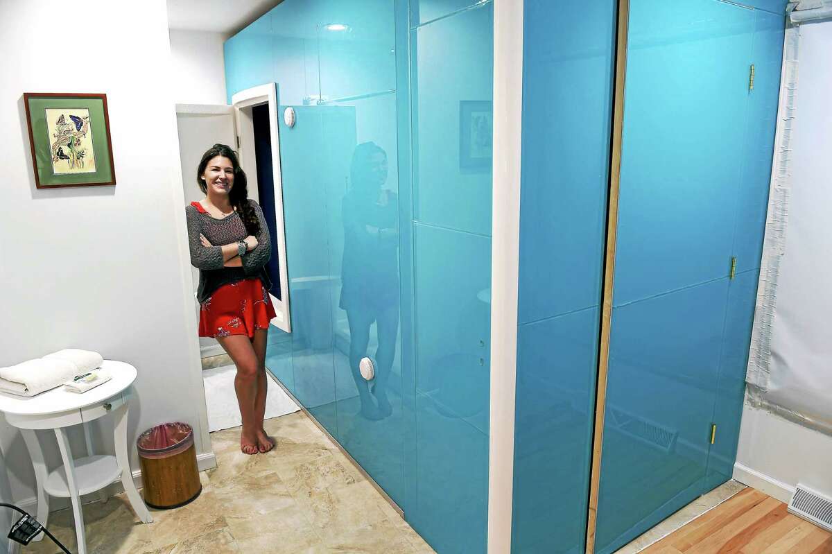 Jocelyn Rustemeyer, co-owner of Surrender to the Float in Guilford, next to a sensory deprivation tank where clients float in salt water.