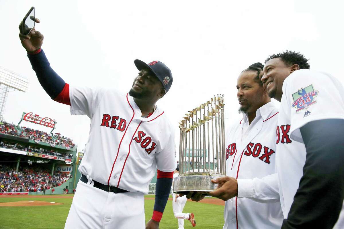David Ortiz, left, takes a selfie with former teammates Manny Ramirez, center, and Pedro Martinez following a ceremony to honor Ortiz before Sunday’s game.