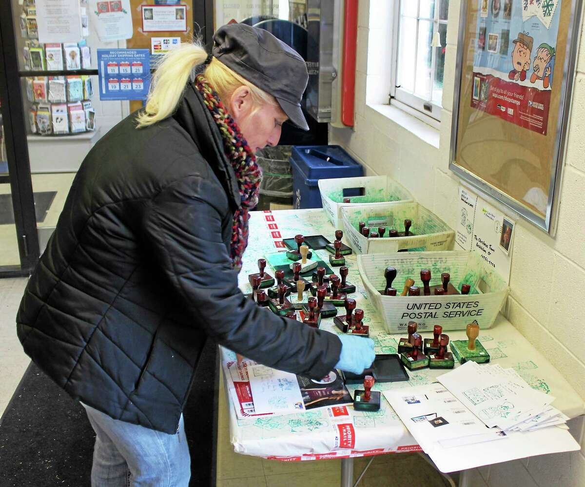 Veronica Gill of Watertown puts the finishing touches on her Christmas cards at the Bethlehem post office