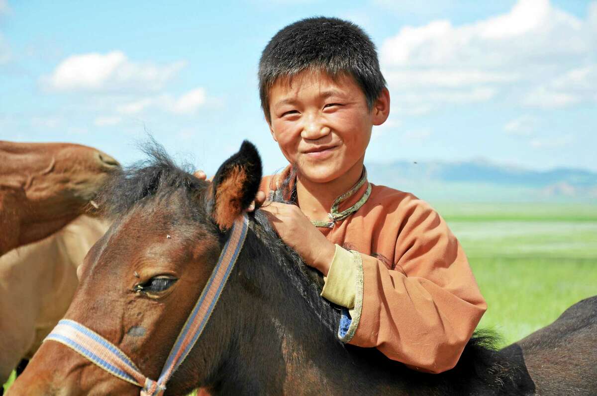 A Mongolian boy with his horses.