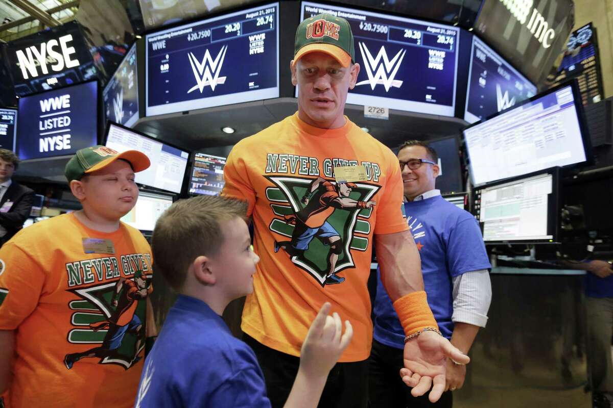 World Wrestling Entertainment Superstar John Cena, center, is accompanied by Make-A-Wish participants Rocco Lanzer, left, and and Evan Maher, as he visits the trading floor before ringing the New York Stock Exchange opening bell, on Friday.