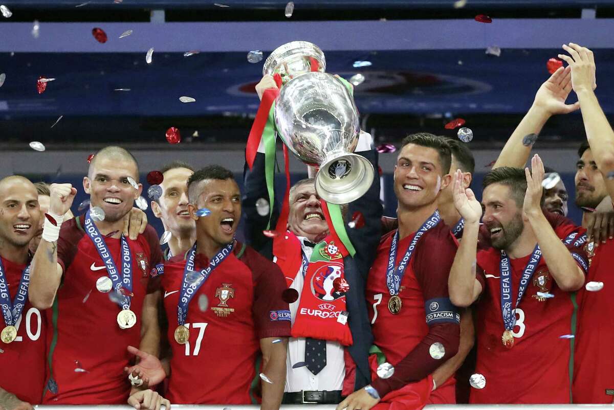 Portugal coach Fernando Santos lifts the trophy between Cristiano Ronaldo, right, and Nani after winning the Euro 2016 final in Saint-Denis, France on Sunday.