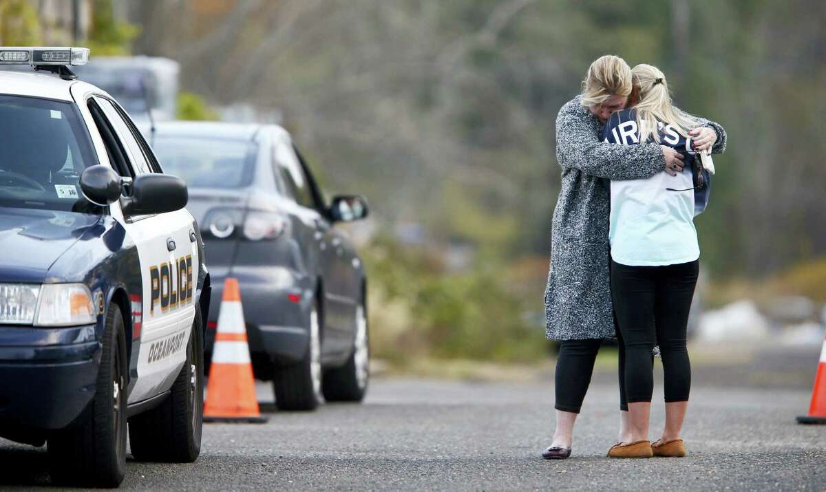 A woman, who police identified as a friend of the victim, is consoled by another woman on the long driveway that leads to the rear of the Froggia Florist and Greenhouses in Oceanport, N.J, where the body of Joseph Comunale, a missing Hofstra University graduate originally from Connecticut, was reportedly found Wednesday, Nov. 16, 2016.