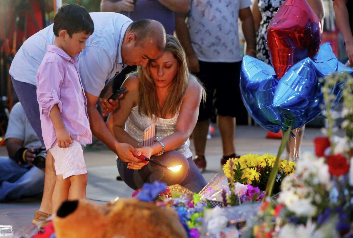 Well-wishers light candles at a makeshift memorial in honor of the slain Dallas police officers in front of police headquarters on Saturday.