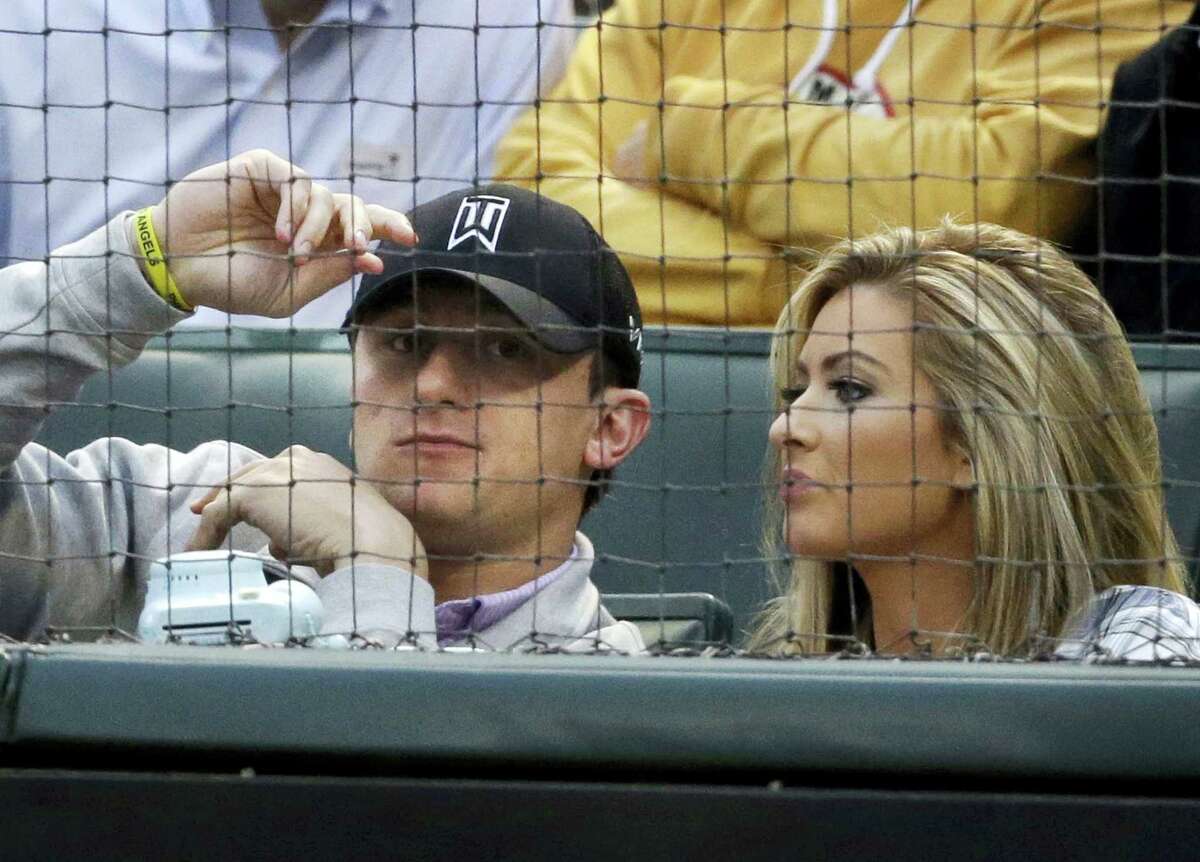 In this 2015 file photo, Browns quarterback Johnny Manziel, left, sits with Colleen Crowley during a baseball game in Arlington, Texas.
