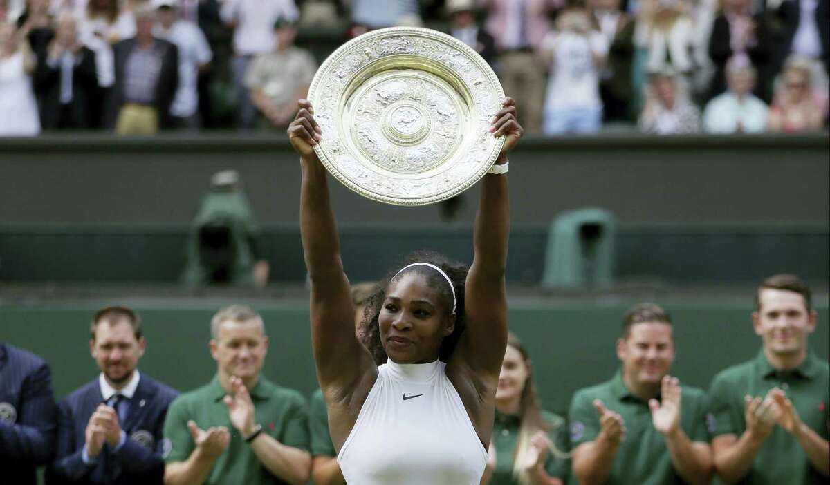Serena Williams holds up her trophy after winning the women’s singles final at Wimbledon on Saturday.