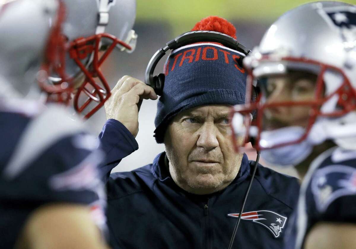 New England head coach Bill Belichick adjusts his headset during Sunday night’s game against Seattle.