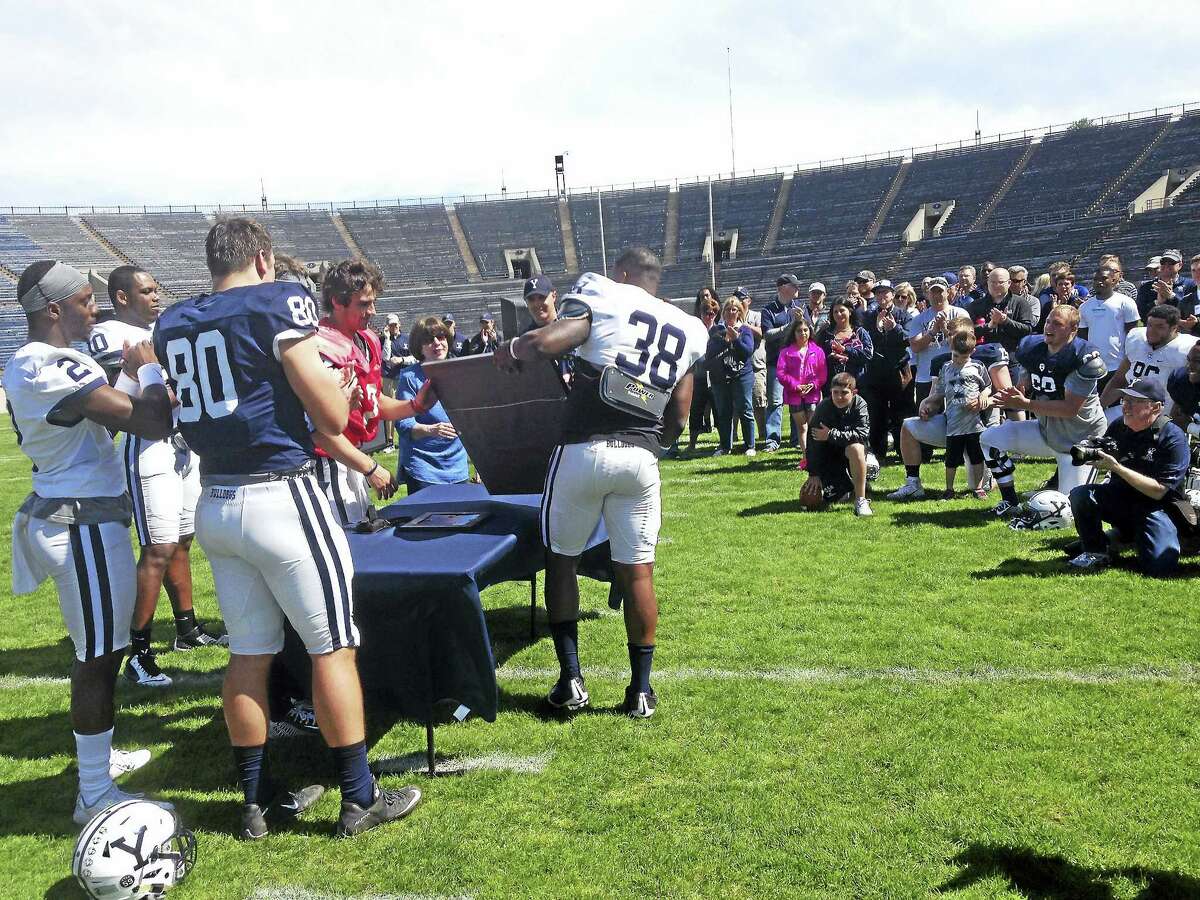 Members of the Yale football team present a plaque to Penny Laurans on Saturday.