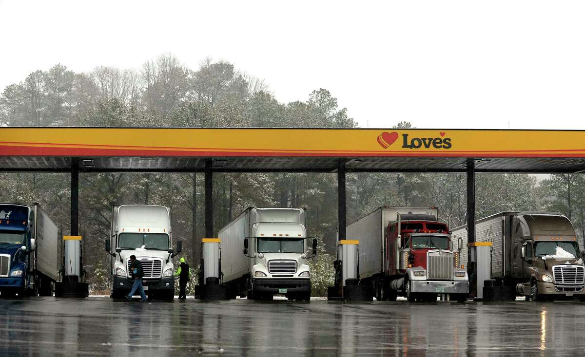 In this Feb. 11, 2014 photo, truck drivers stop at a gas station in Emerson, Ga., north of metro Atlanta, to fill up their tractor trailer rigs. A new government rule being announced by the Federal Motor Carrier Safety Administration on Thursday, Dec. 10, 2015, requires an estimated 3 million commercial truck and bus drivers to electronically record their hours behind the wheel in an effort to enforce regulations to prevent fatigue.