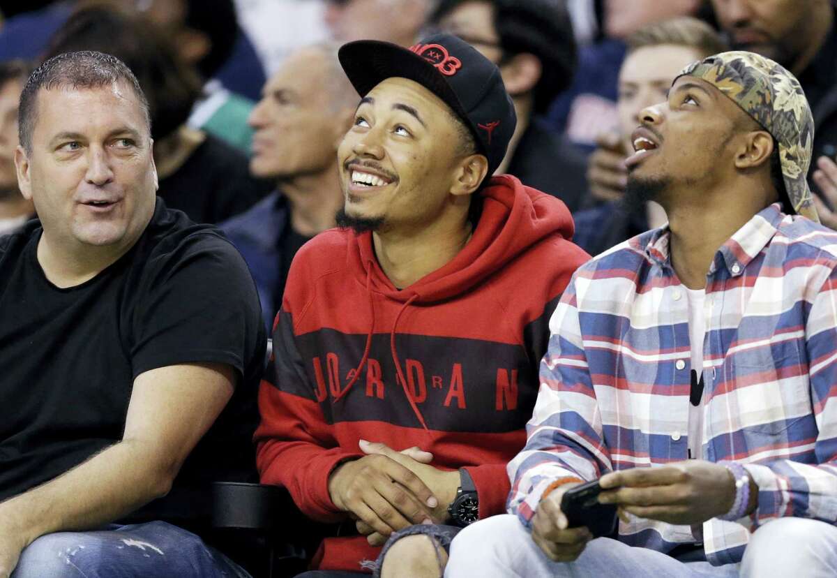 Boston Red Sox baseball player Mookie Betts, center, sits courtside in the first quarter of an NBA basketball game between the Boston Celtics and the New York Knicks, Friday, Nov. 11, 2016, in Boston. (AP Photo/Elise Amendola)
