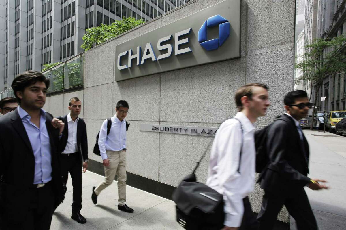 In this Monday, July 13, 2015 photo, pedestrians pass a Chase Bank office tower in New York's financial center. Federal regulators on Monday, July 20, 2015 are directing the eight biggest U.S. banks to hold capital at levels above industry requirements, to cushion against unexpected losses and reduce the chances of future taxpayer bailouts. JPMorgan Chase is the only one that doesn't already meet the requirements.