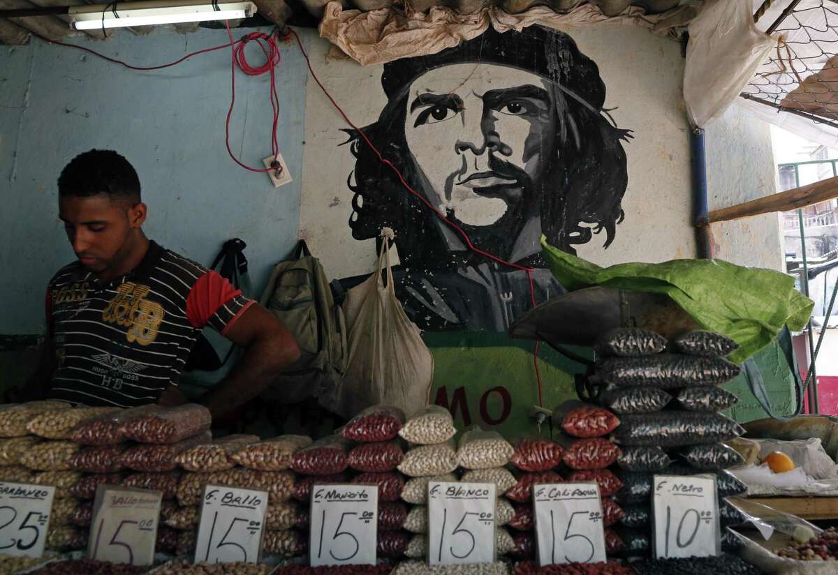 A man works at a bean stall at a market beside a mural with the a picture of revolution hero Ernesto “Che” Guevara in Havana, Cuba, Thursday, April 9, 2015. President Barack Obama signaled Thursday he will soon remove Cuba from the U.S. list of state sponsors of terrorism, boosting hopes for improved ties as he prepared for a historic encounter with Cuban President Raul Castro during the Summit of the Americas taking place in Panama.