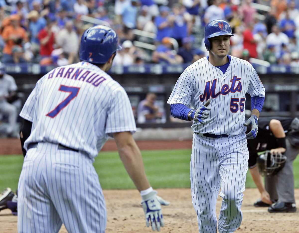 New York Mets’ Kelly Johnson is greeted by Travis d’Arnaud after he hit a home run during the fifth inning against the Colorado Rockies on Thursday.