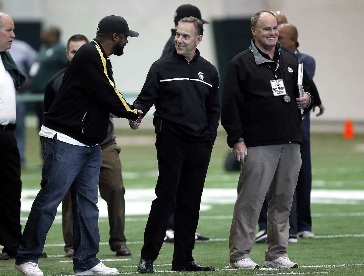 Pittsburgh Steelers head coach Mike Tomlin, left, shakes hands with Michigan State head coach Mark Dantonio, center, as Steelers general manager Kevin Colbert looks on during a pro day on March 18 in East Lansing, Mich.