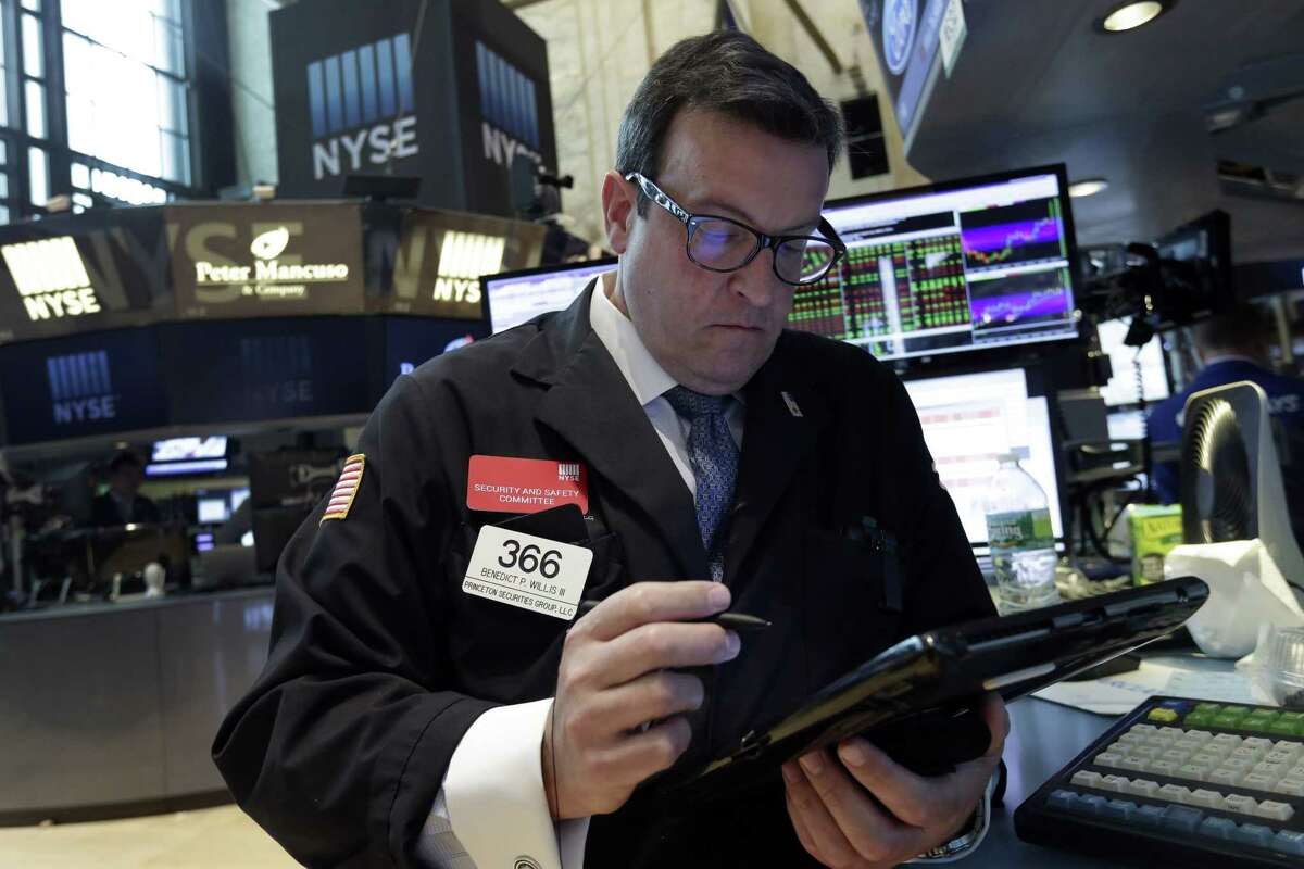 Trader Bebedict Willis works on the floor of the New York Stock Exchange on Aug. 12, 2015. Another drop in China’s currency sent global markets mostly lower on Wednesday as the move raised worries about the world’s second-largest economy, but U.S. stocks recovered most of their losses in late trading.
