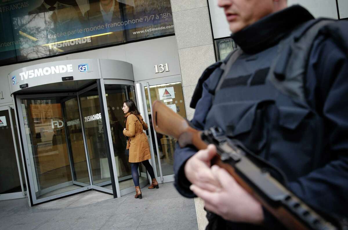 A policeman stands guard in front of TV5 Monde headquarters in Paris, France, Thursday April 9, 2015. A French television network has been hacked by people claiming allegiance to the Islamic State group, the channel's director said Thursday. The hackers briefly cut transmission of 11 channels belonging to TV5 Monde and took over its websites and social media accounts. (AP Photo/Christophe Ena)