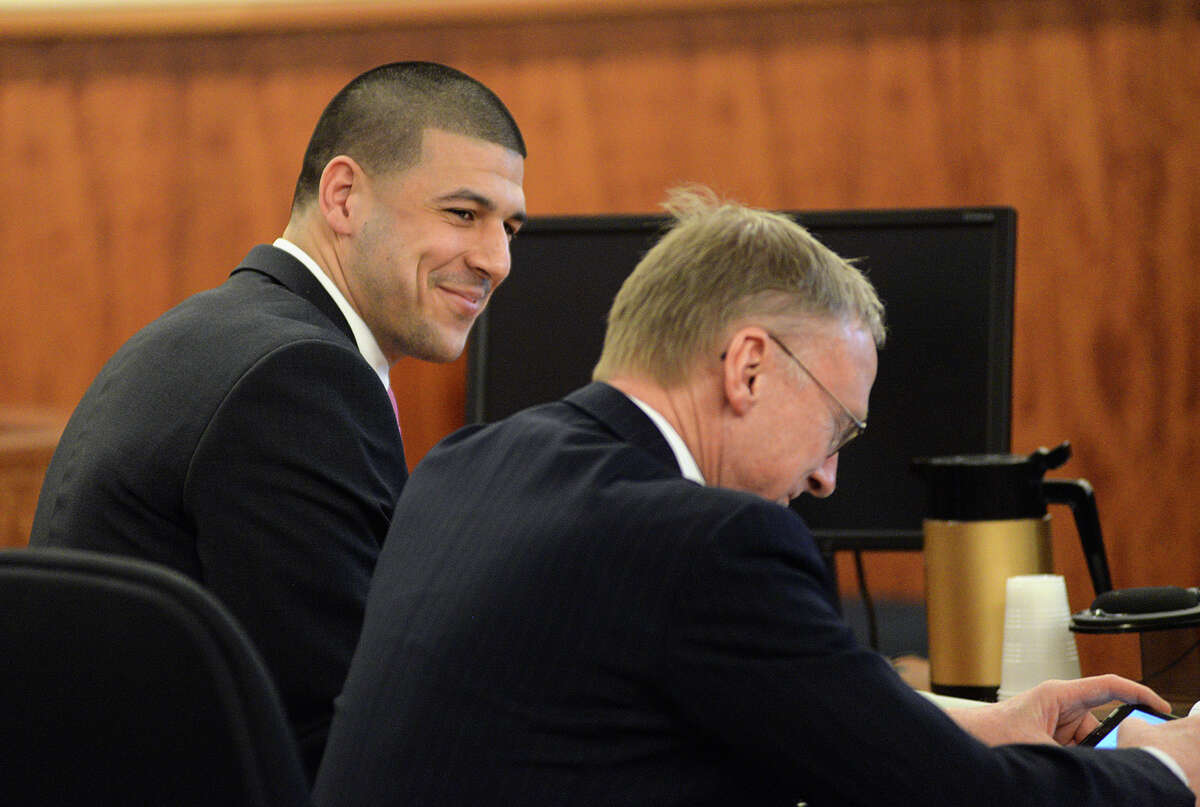 Former New England Patriots football player Aaron Hernandez smiles with defense attorney Charles Rankin in the courtroom of the Bristol County Superior Court House in Fall River, Mass., Wednesday, April 8, 2015. The fate of Hernandez is now in the hands of a jury, which began its first full day of deliberations Wednesday in his murder trial. Hernandez is charged with the June 2013 shooting death of Odin Lloyd. (AP Photo/Faith Ninivaggi, Pool)