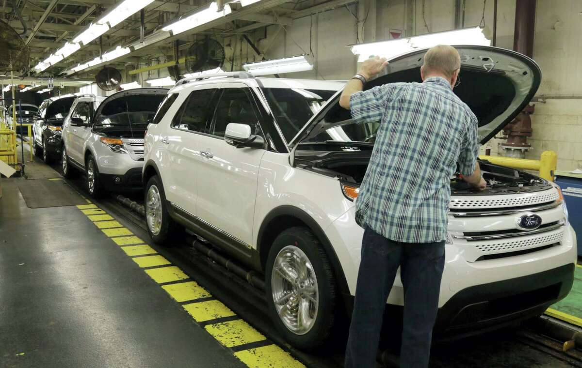 In this Oct. 22, 2014 photo, workers perform final inspections on 2015 Ford Explorers on the assembly line at the Chicago Ford Assembly Plant in Chicago.