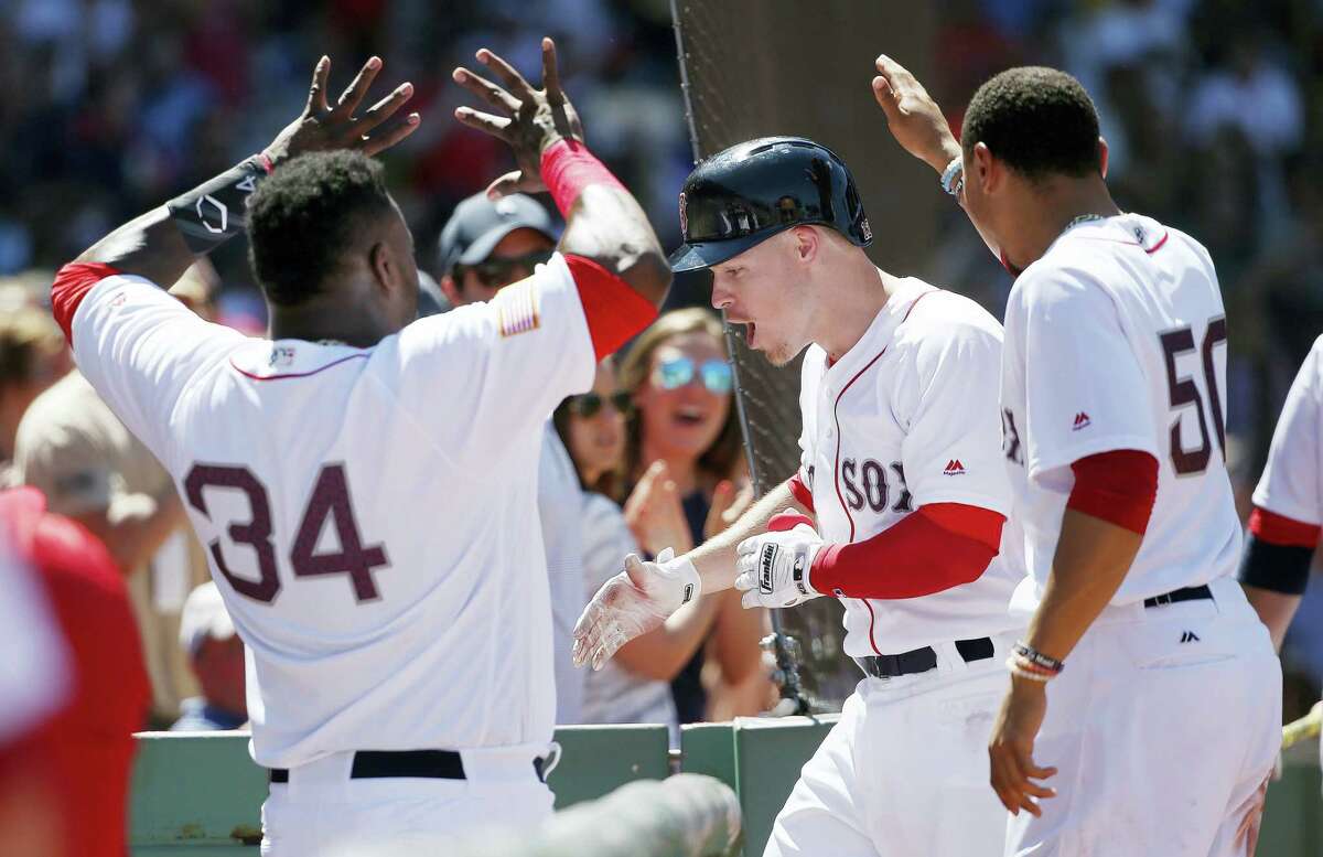 Boston’s Brock Holt, center, celebrates his two-run home run during the third inning against the Texas Rangers in Boston. The Red Sox won 12-5.