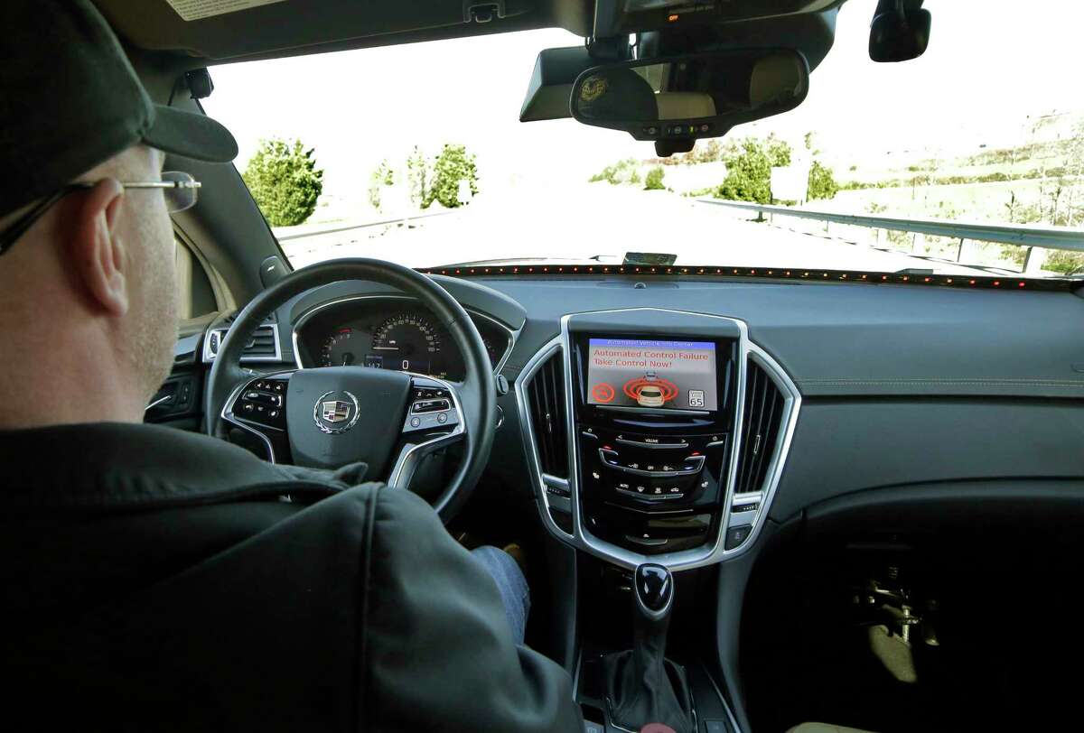 Virginia Tech Center for Technology Development Program Administration Specialist Greg Brown behind the wheel of a driverless car during a test ride showing the alert system handing over automation to the driver while traveling street in Blacksburg, Va.