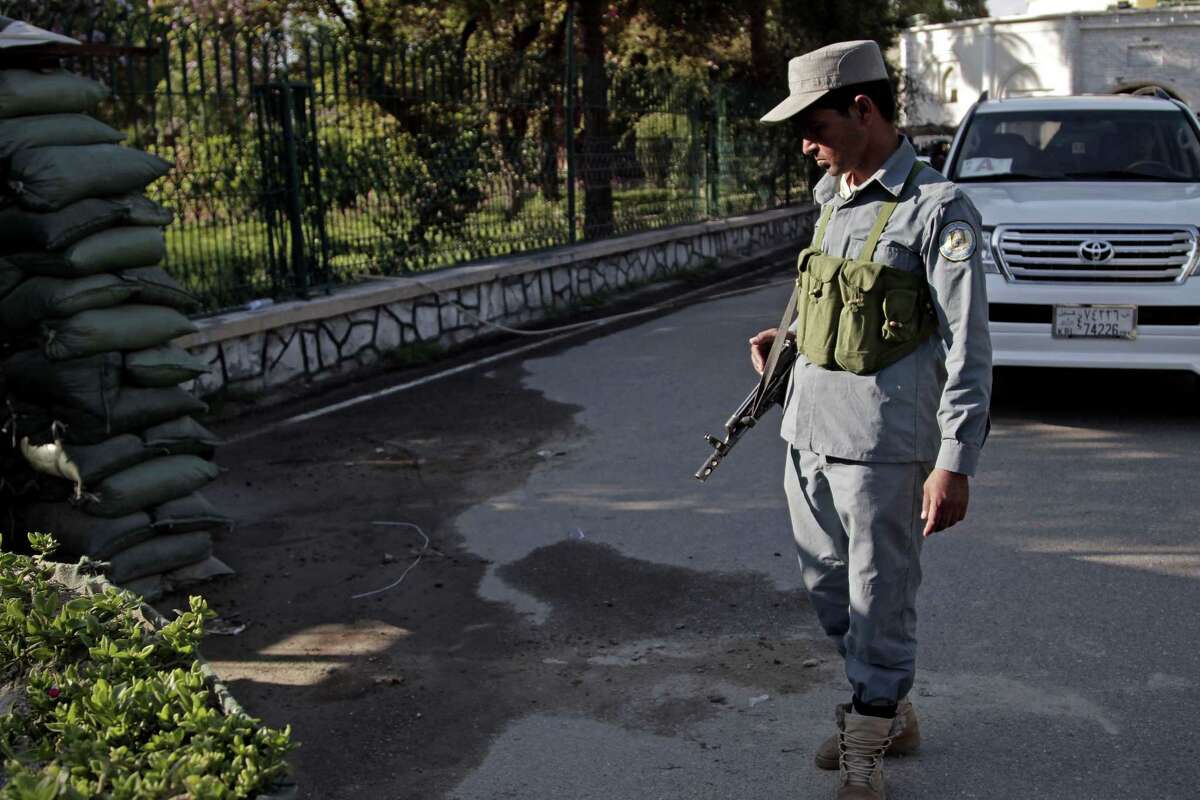 An Afghan policeman looks at a bloodstained pavement at the site of an attack by an Afghan national army soldier who opened fire on U.S. troops, at the compound of the provincial governor, in Jalalabad, Afghanistan on April 8, 2015.