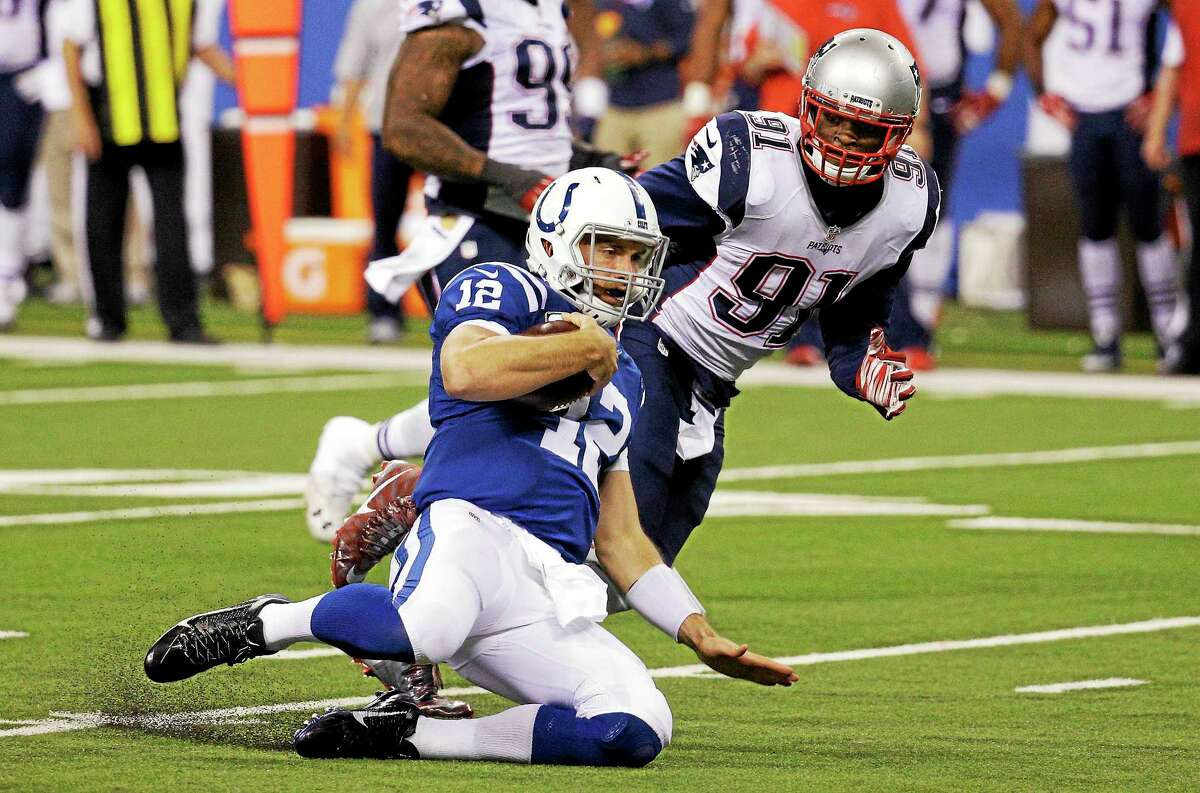 Indianapolis Colts quarterback Andrew Luck slides with the ball as New England Patriots linebacker Jamie Collins gives chase.