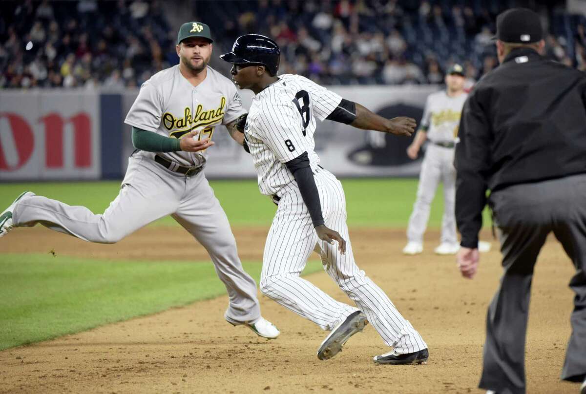 The Yankees’ Didi Gregorius is tagged out by Athletics first baseman Yonder Alonso, left, after being caught in a rundown during the fifth inning on Tuesday.
