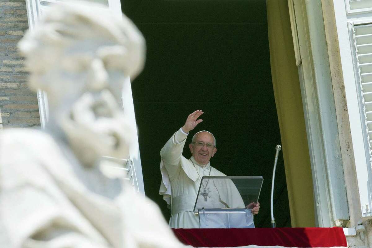 Pope Francis delivers his blessing during the Angelus noon prayer he celebrated from the window of his studio overlooking St. Peter’s Square at the Vatican Sunday.