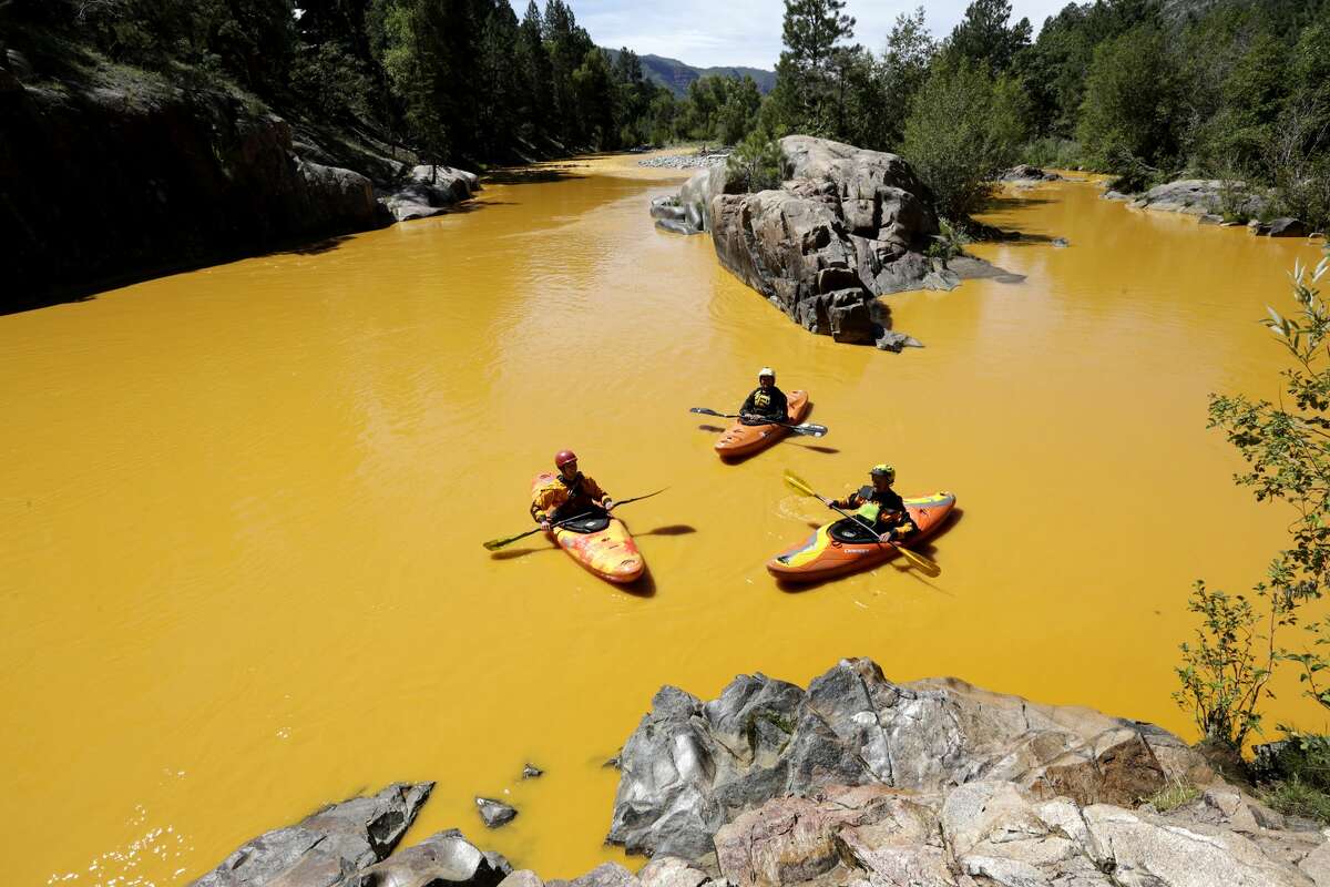FILE - In this Thursday, Aug. 6, 2015 file photo, people kayak in the Animas River near Durango, Colo., in water colored yellow from a mine waste spill. A crew supervised by the U.S. Environmental Protection Agency has been blamed for causing the spill while attempting to clean up the area near the abandoned Gold King Mine. Tribal officials with the Navajo Nation declared an emergency on Monday, Aug. 10, as the massive plume of contaminated wastewater flowed down the San Juan River toward Lake Powell in Utah, which supplies much of the water to the Southwest.