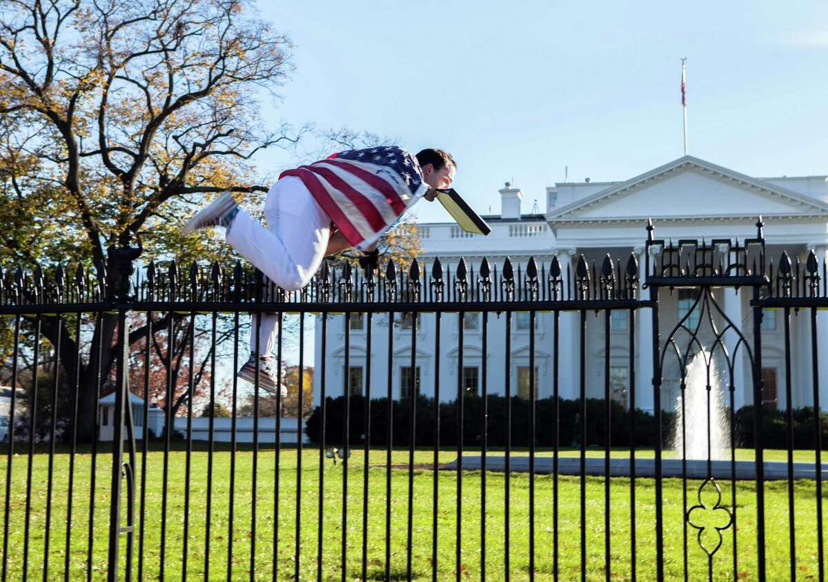 Joseph Caputo, 22, of Connecticut, jumps a fence at the White House on Thanksgiving in Washington.