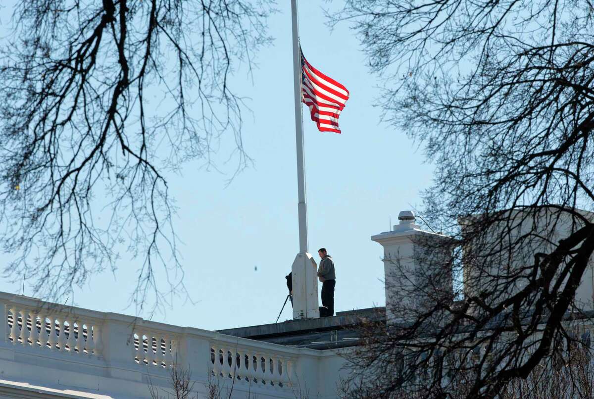 Workers lower the American flag above the White House in Washington, Thursday, Dec. 3, 2015. President Barack Obama ordered that flags be lowered at all government buildings to honor the victims of yesterday’s mass shooting in San Bernardino, Calif.
