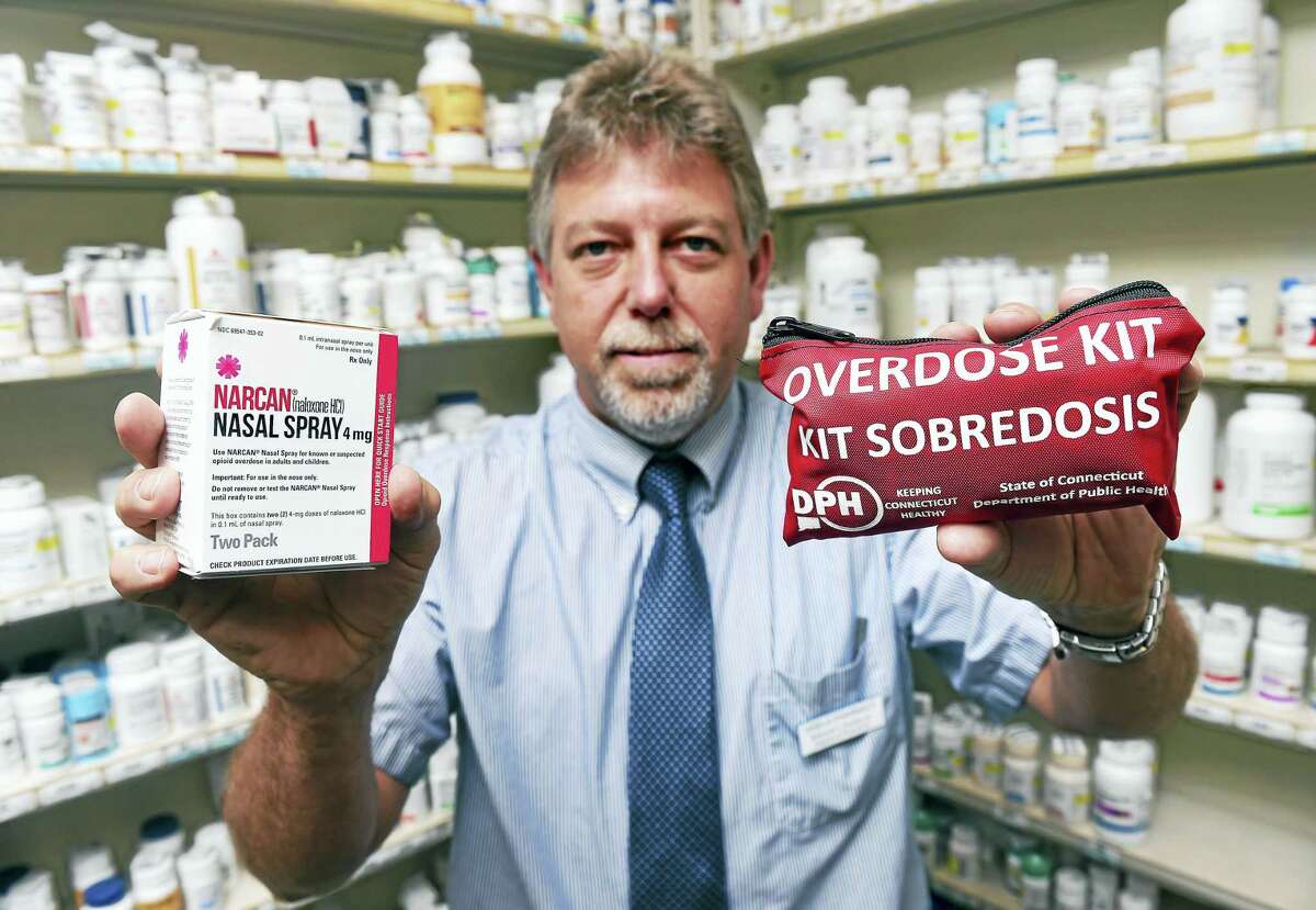 Edmund Funaro Jr., director of Visels Pharmacy, holds Narcan nasal spray, left, and a Connecticut Department of Public Health overdose kit at the pharmacy in New Haven.
