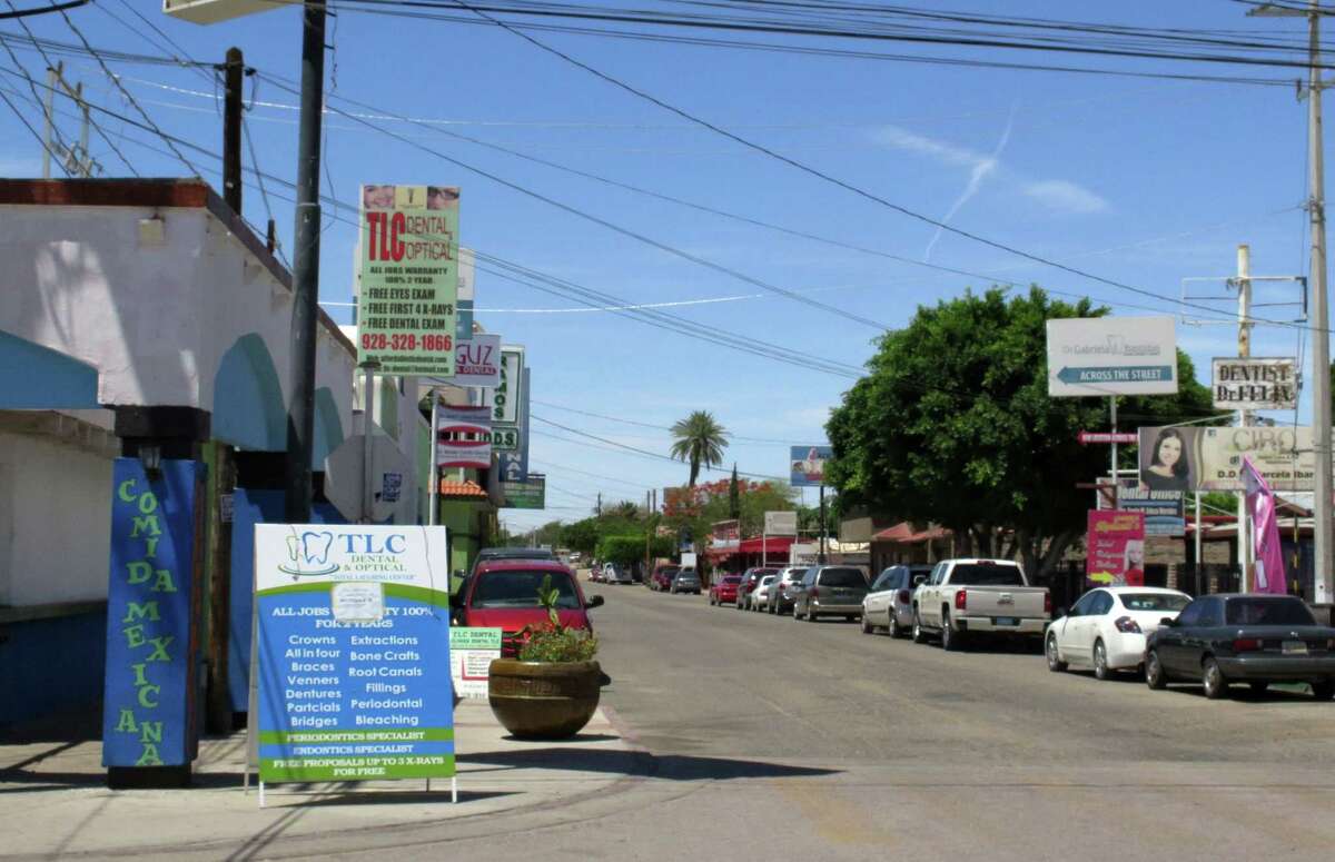 In this Thursday, April 30, 2015 photo, a street full of a dental offices is seen in Los Algodones, Mexico, which sits on the border with California. Thousands of Americans and Canadians travel to Los Algodones each year for affordable and reliable dental work from dentists who speak English and sometimes accept U.S. insurance. The trip, even counting the cost of traveling long distances, is often more affordable than getting dental care in the United States.