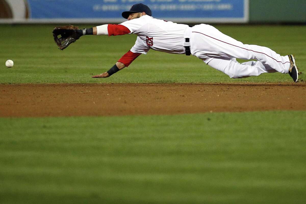 Boston Red Sox second baseman Dustin Pedroia can't make a diving grab on a Minnesota Twins base hit in the fourth inning of a spring training exhibition baseball game Friday, April 3, 2015, in Fort Myers, Fla. The Twins beat the Red Sox 5-2. (AP Photo/Naples Daily News, Corey Perrine)