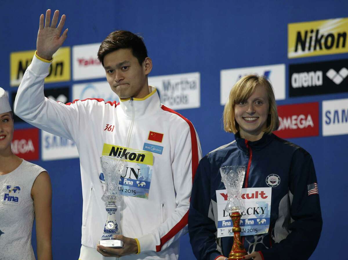 China’s Sun Yang, left, and the United States’ Katie Ledecky present the awards as best athletes of the competition Sunday at the end of the Swimming World Championships in Kazan, Russia.