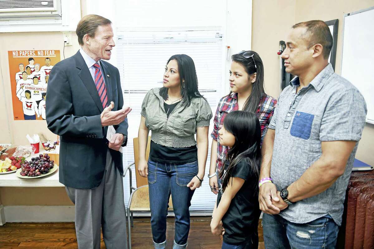 U.S. Senator Richard Blumenthal (left) talks with Ana Lucero Castillo (center), Isaias Olivares (right) and their children, Naamy, 13, and Melanie, 9, at Junta for Progressive Action in New Haven on 4/17/2016. The family plans to join thousands of others outside of the U.S. Supreme Court during oral arguments challenging the DAPA and DACA programs.