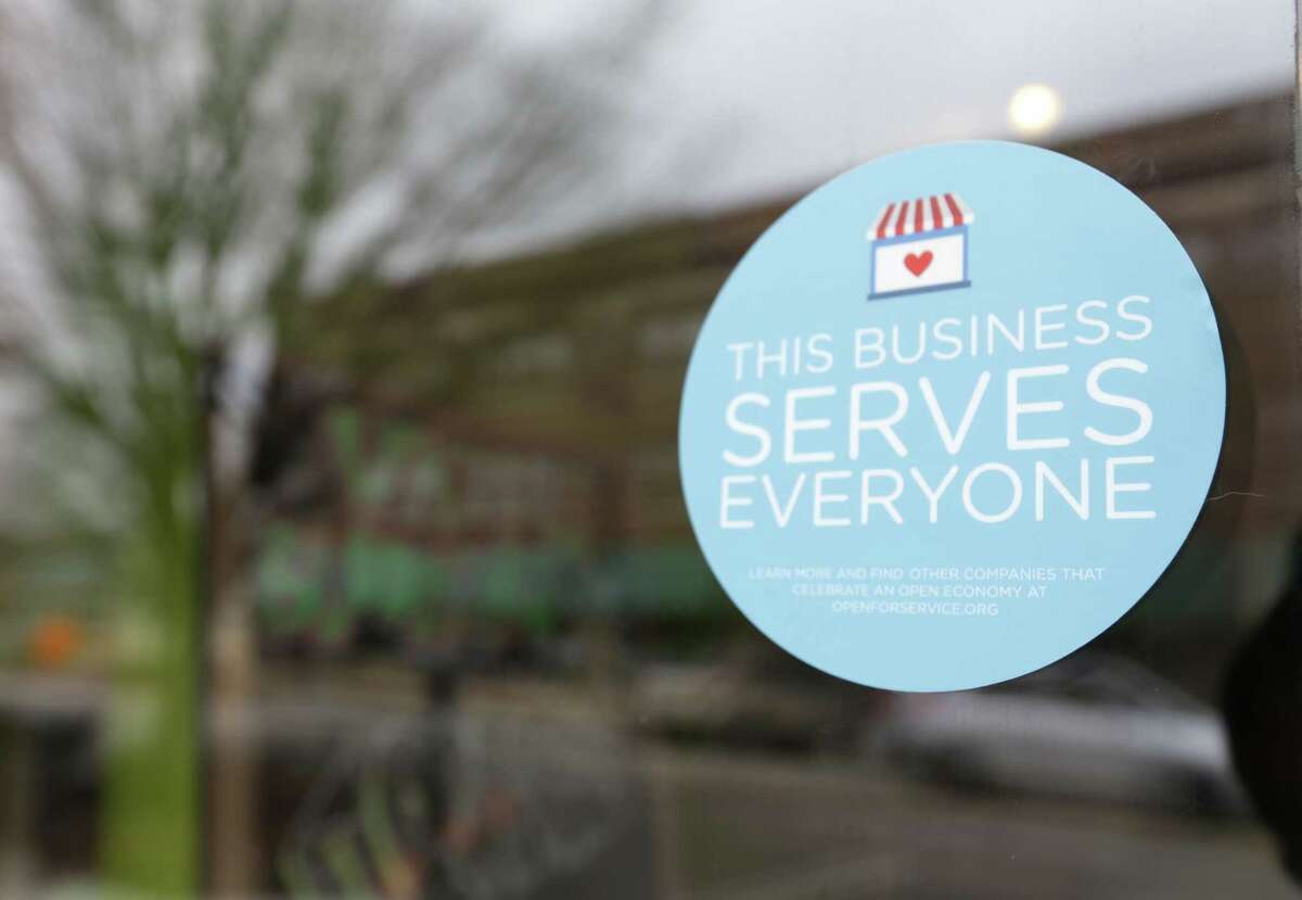 In this March 25, 2015 photo, a window sticker promising service to all is displayed in opposition to the state new religious objections law in downtown Indianapolis.