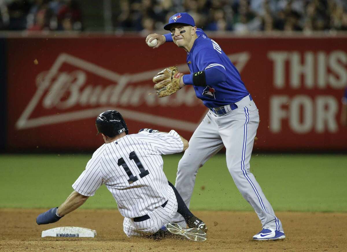 Toronto Blue Jays shortstop Troy Tulowitzki turns a double play as the New York Yankees’ Brett Gardner slides into second during Friday night’s game.