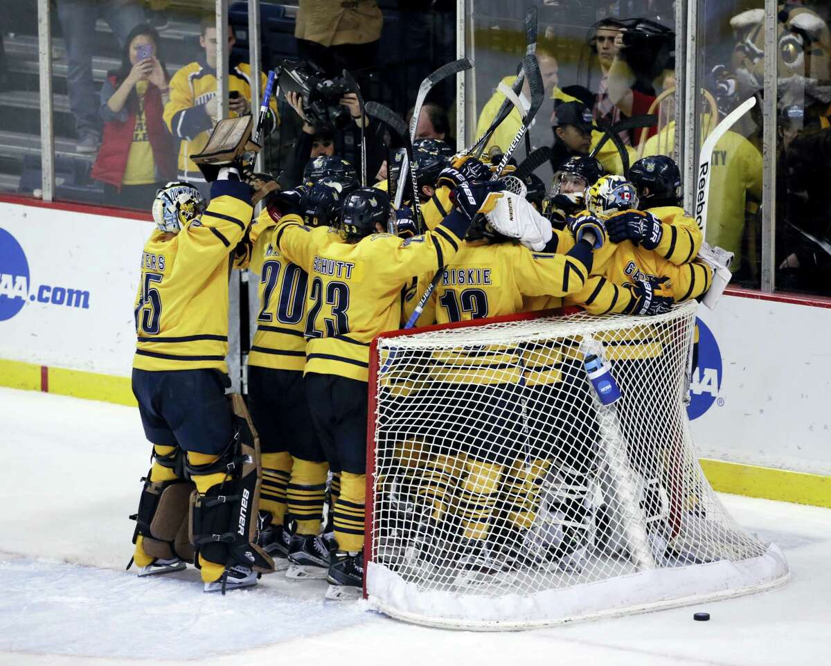 Members of the Quinnipiac hockey team celebrate their win over UMass Lowell in the NCAA East Regional championship.