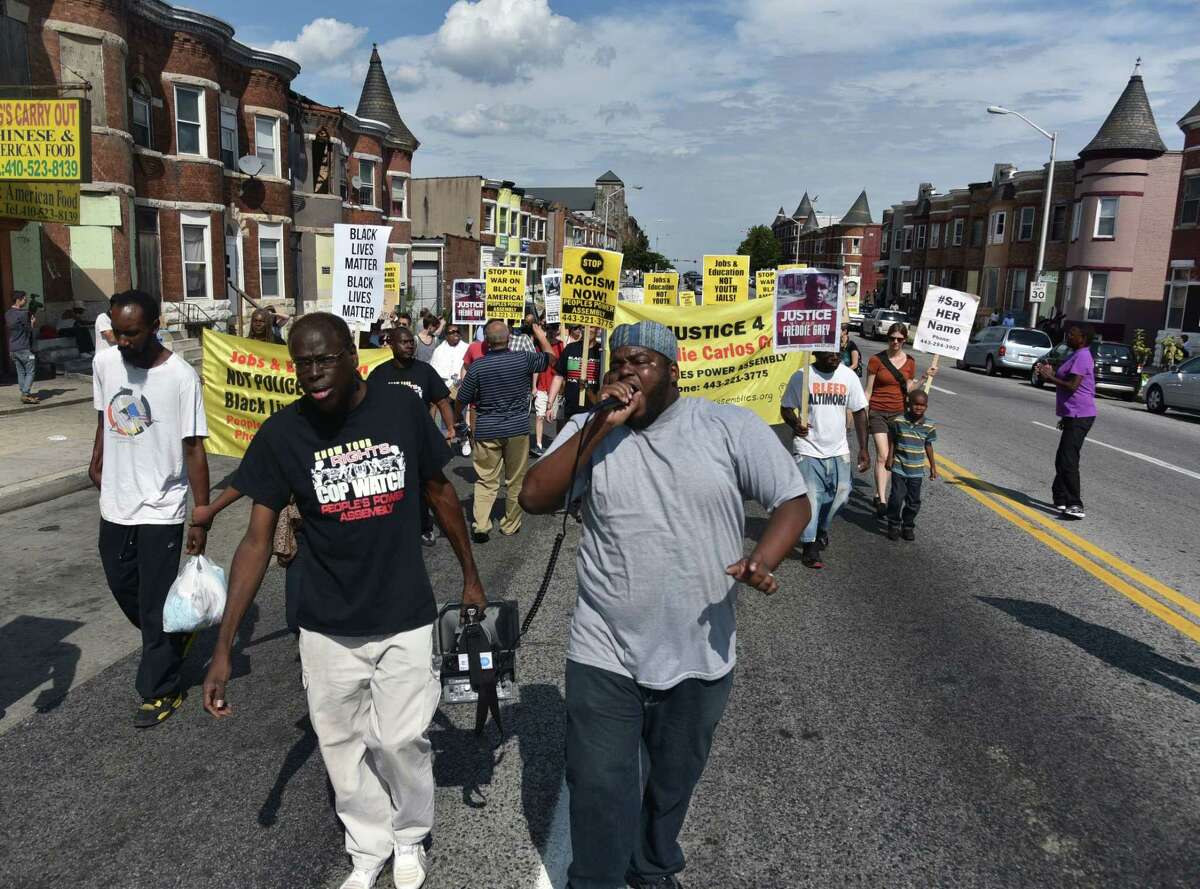 Andre Powell, left, an organizer with Baltimore People’s Power Assembly, and Rev. C.D. Witherspoon, president of the Baltimore SCLC, lead a march on North Avenue in Baltimore on Aug. 8 2015, the eve of the anniversary of Michael Brown’s death during a confrontation with a police officer.
