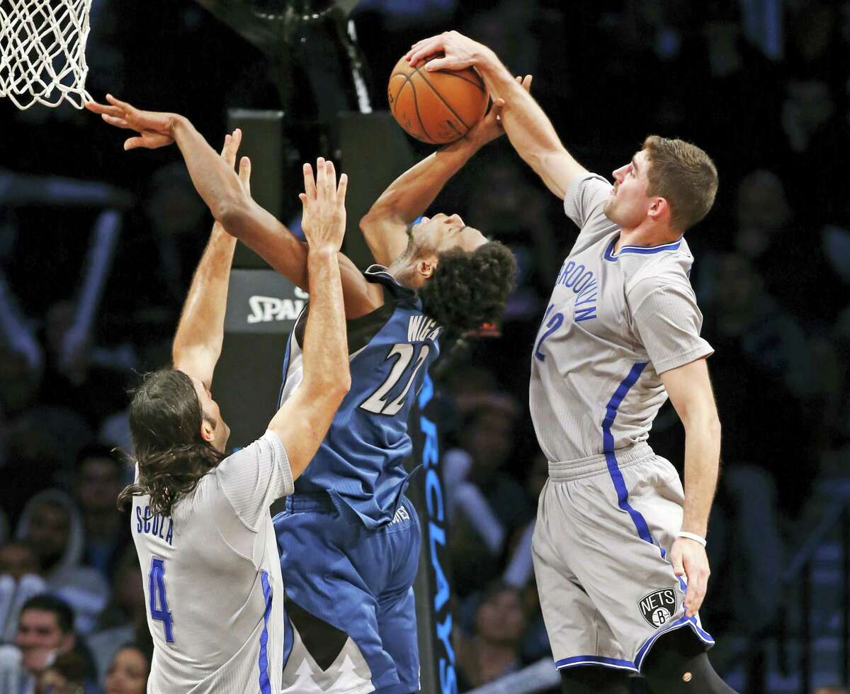 Brooklyn Nets guard Joe Harris (12) steals the ball from Minnesota Timberwolves forward Andrew Wiggins (22) as Brooklyn Nets’ forward Luis Scola (4) defends Wiggins during the second half Tuesday in New York. The Nets defeated the Timberwolves 119-110.