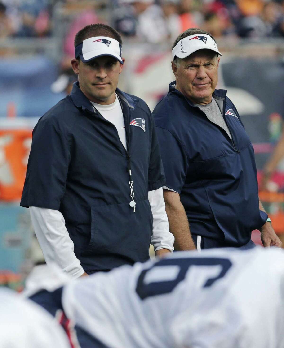 New England Patriots coach Bill Belichick, right, and offensive coordinator Josh McDaniels watch practice on Wednesday in Foxborough, Mass.