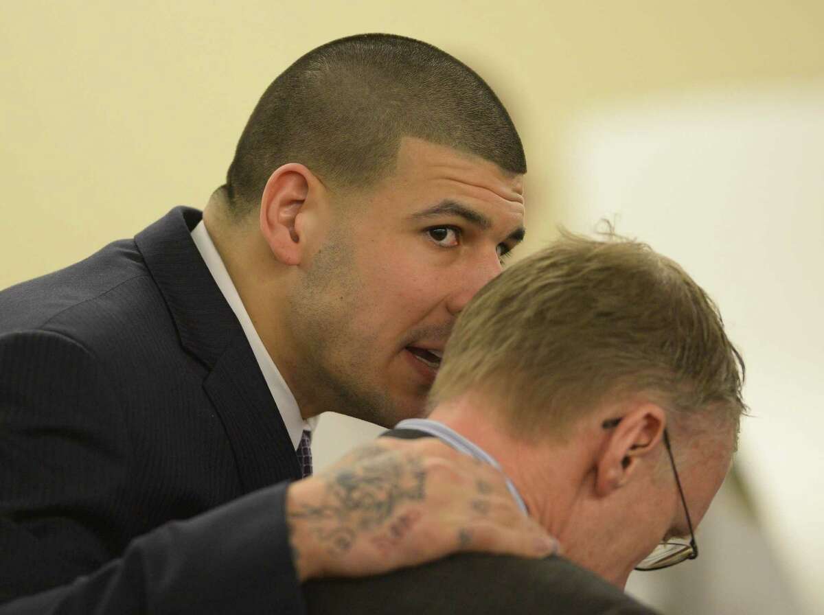 Aaron Hernandez talks with his attorney, Charles Rankin, during his murder trial Friday at the Bristol County Superior Court in Fall River, Mass.